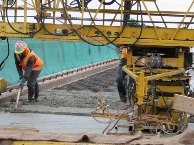 Screed machine finishing new concrete deck surface