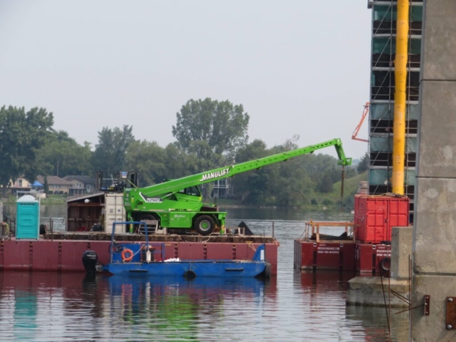 Using the manlift to move materials onto the pier 10 barge