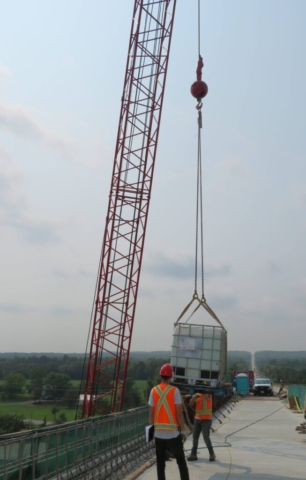 110-ton crane lowering the water tote containing burlap onto the deck