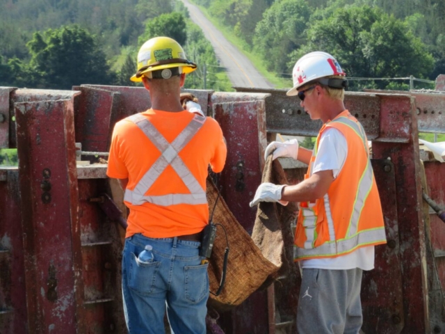 Placing wet burlap on the newly placed barrier wall concrete