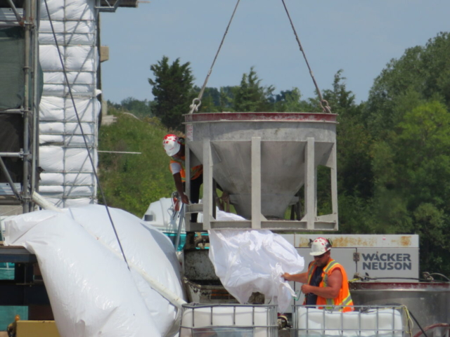 Lowering the hopper with the Manlift to the concrete pump