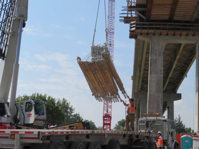 Loading the removed work platform brackets onto the truck using the hydraulic crane