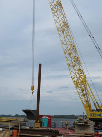 Lowering the full containment bin to the barge