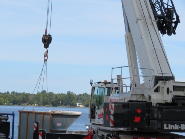 Using the 160-ton crane to load full containment bin onto the barge