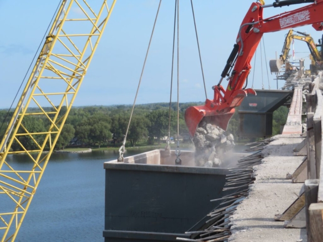 Using the bucket to place concrete rubble into the containment bin