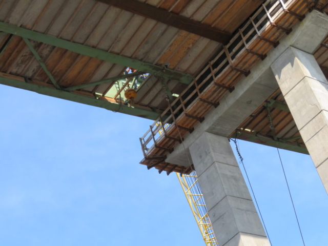 Lowering the crane ball through the false decking to lift the anchor cables