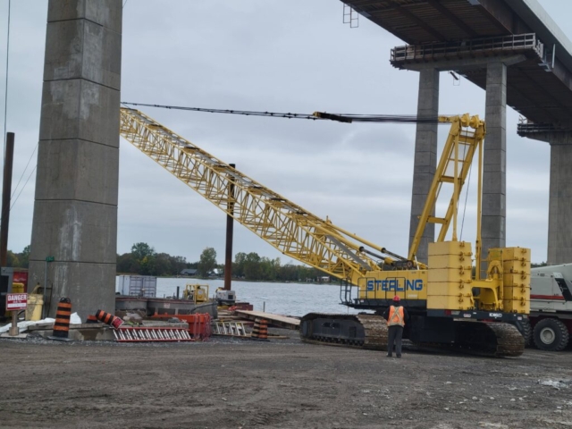 200-ton crane being removed from the barge, under the bridge