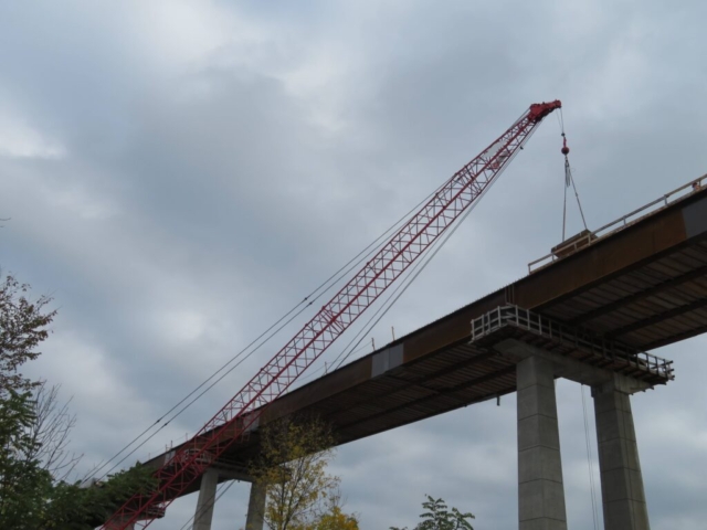 110-ton crane lowering work platform materials to the bridge deck