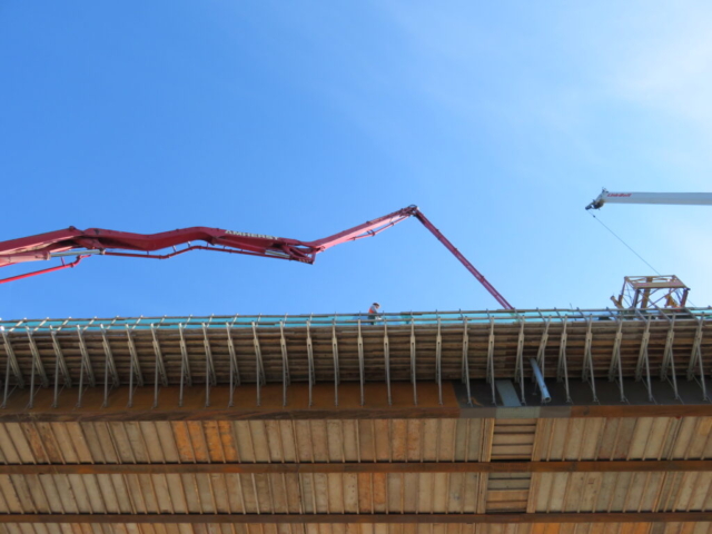 View from below of concrete pump lifted to the deck