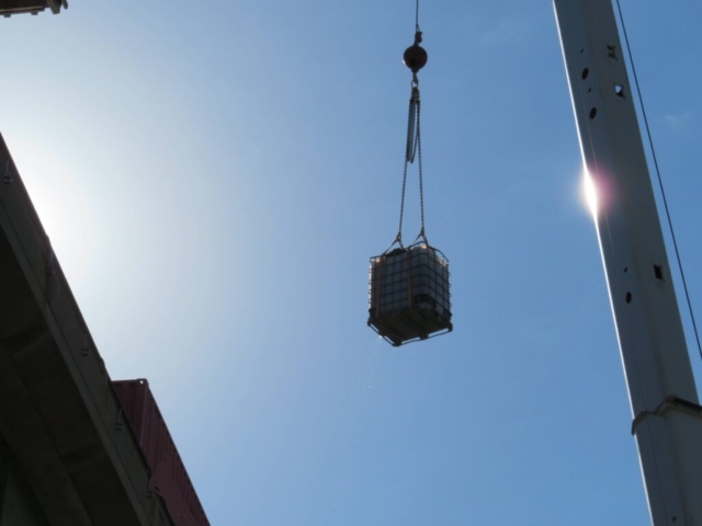 160-ton crane lifting the tote of water and burlap to the deck