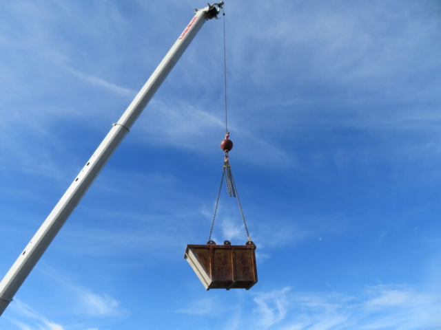 160-ton crane lowering the containment bin from the deck