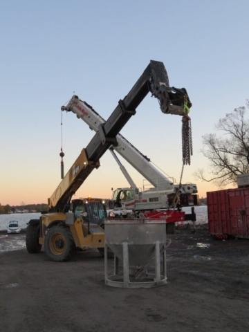 Telehandler moving the concrete hopper into place prior to deck placement