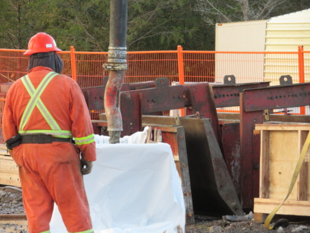 Concrete pump releasing slurry into the containment bin