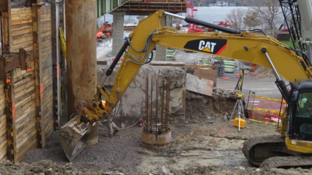Excavator placing granular prior to mud slab placement