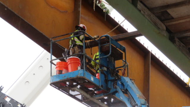Installing bracing between the existing girder and the new girder