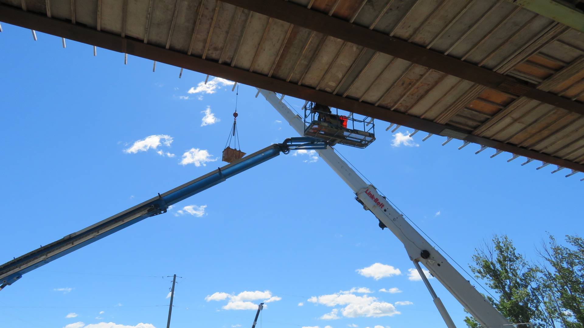160-ton crane lifting the debris bucket, manlift used to tighten the brackets