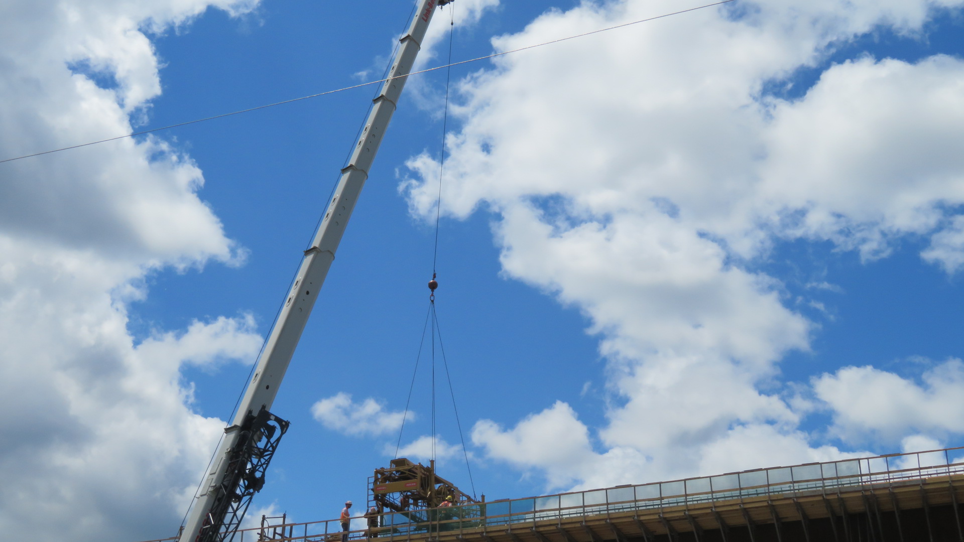 160-ton crane lowering the concrete finisher to the bridge deck