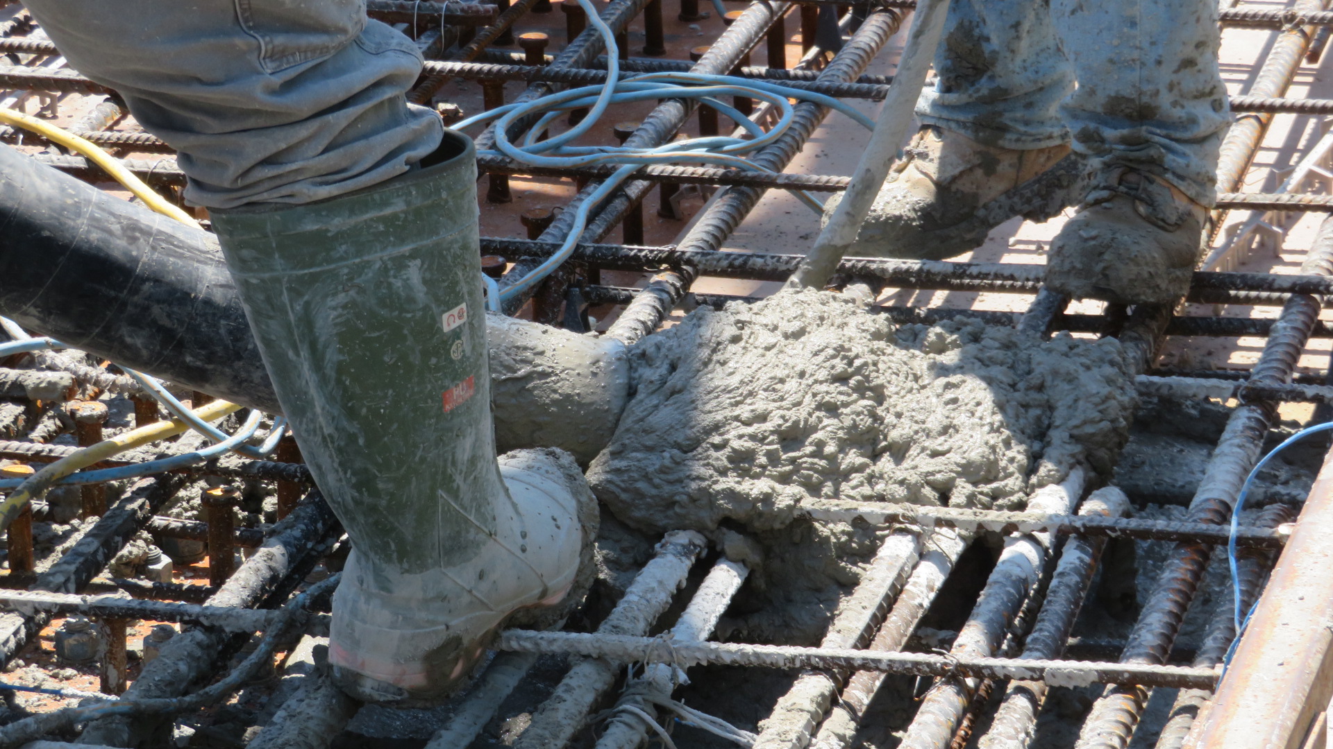 Close-up of concrete being pumped into the forms and vibrated