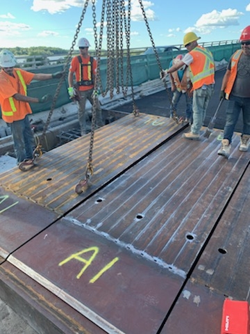 Lowering the temporary reinforced deck panel into place