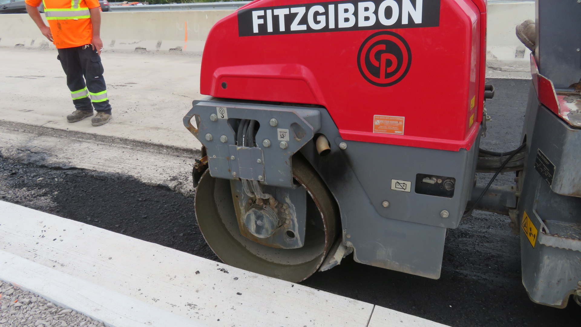 Close-up, using the steel roller on the newly placed asphalt