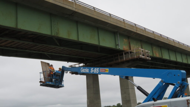 Using the manlift to install the false decking on the north side of the bridge