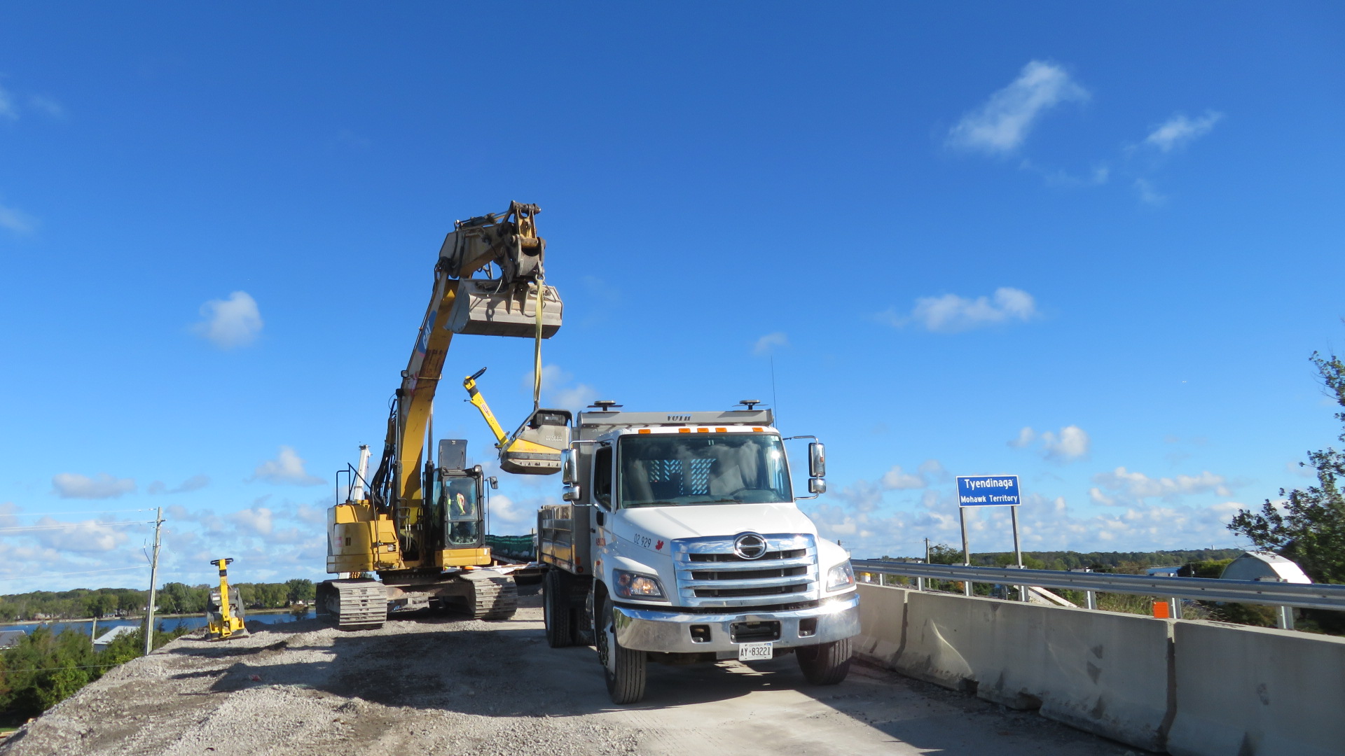 Using the excavator to lift the tamping machine to the truck