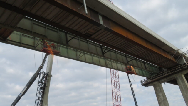 Two man-lifts being used to remove the bracing between girders