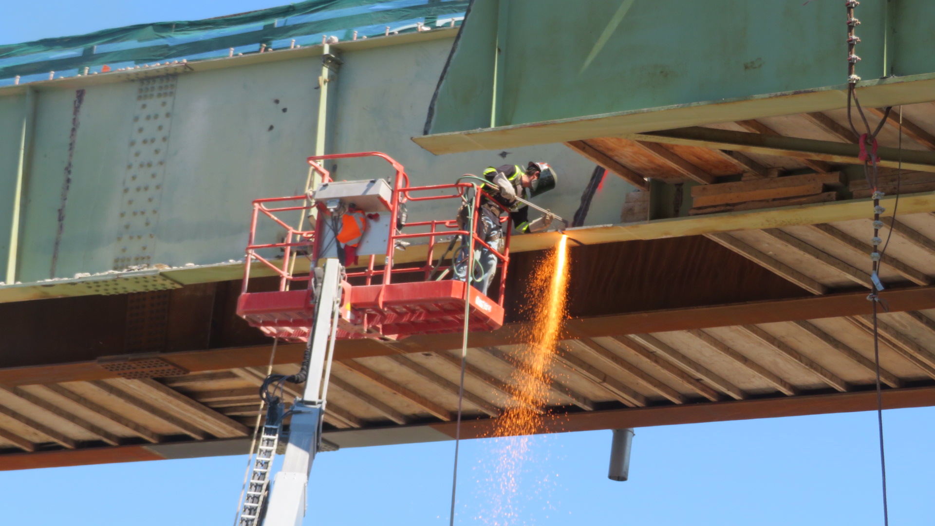 Torch cutting the bottom flange on the second girder section for removal