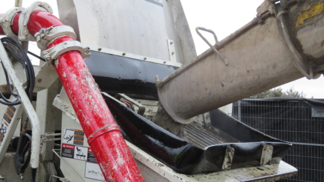 Close-up, placing concrete into the concrete pump