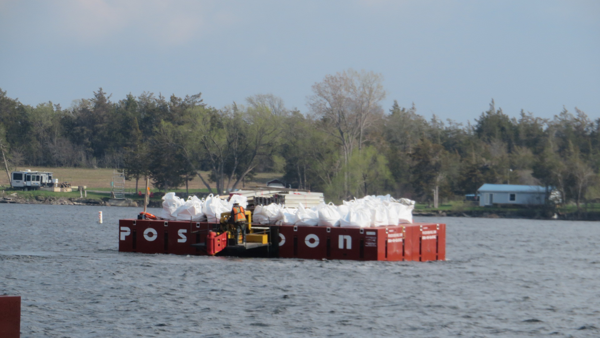 Service barge removing bags of debris to the dock