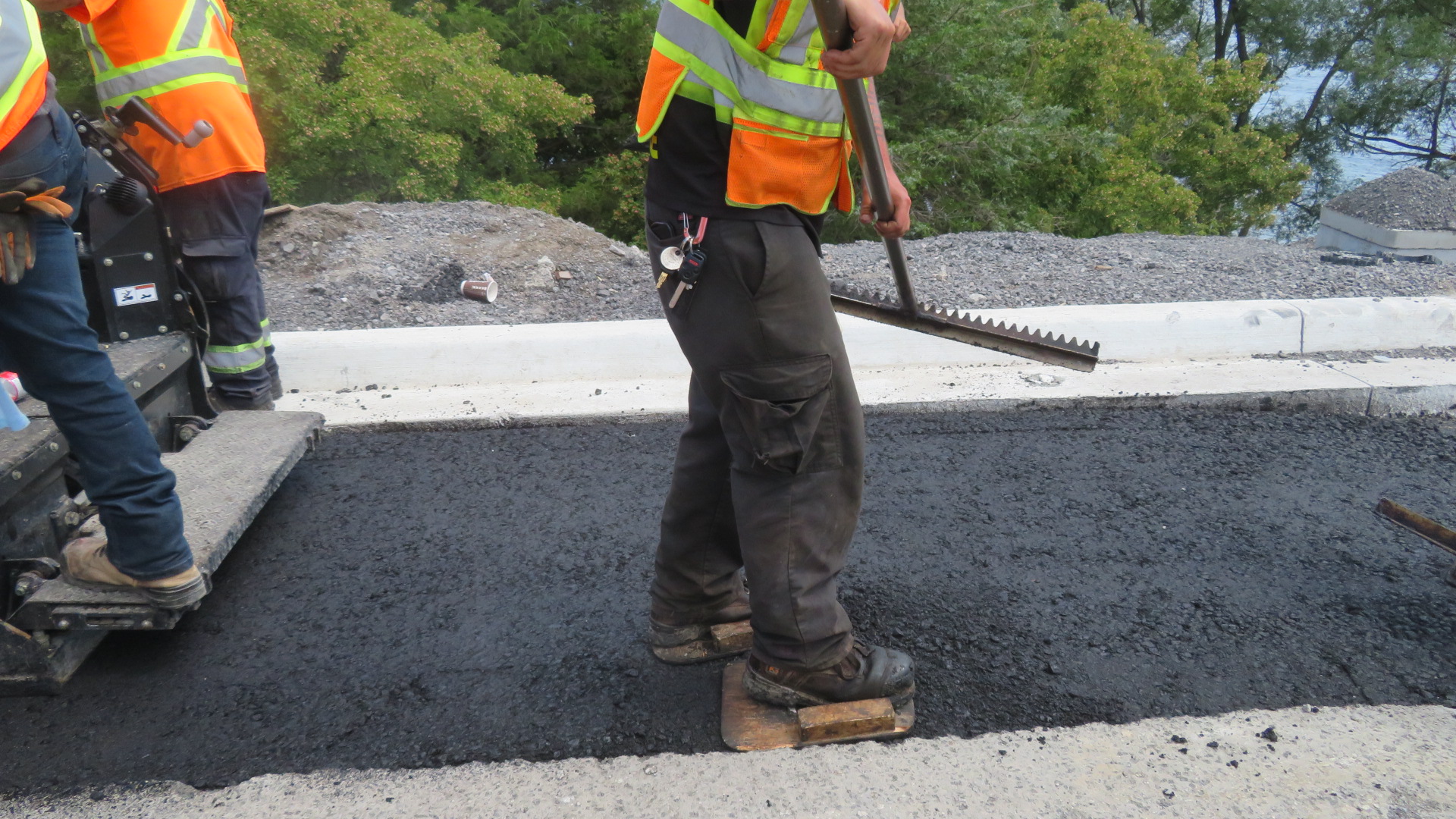 Tamping the newly placed asphalt